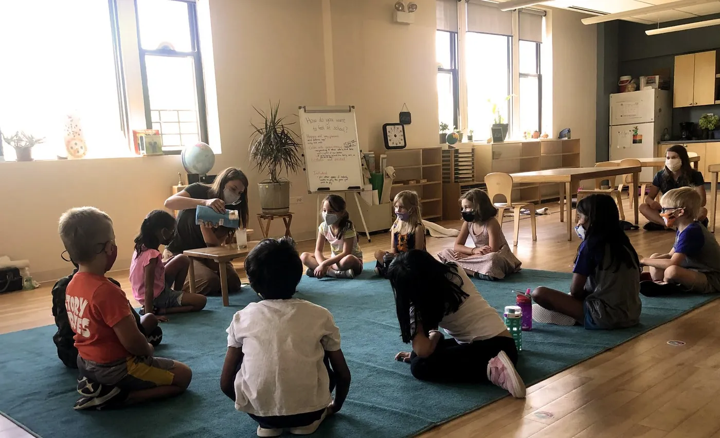 Children working on the floor of a Montessori classroom at Montessori Academy of Chicago