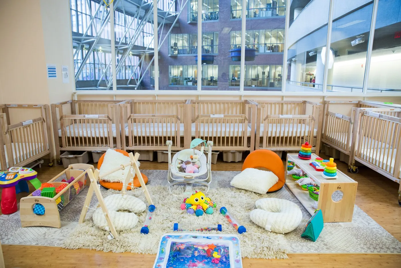 Infant room with cribs and floor play area at Transportation Children’s Center