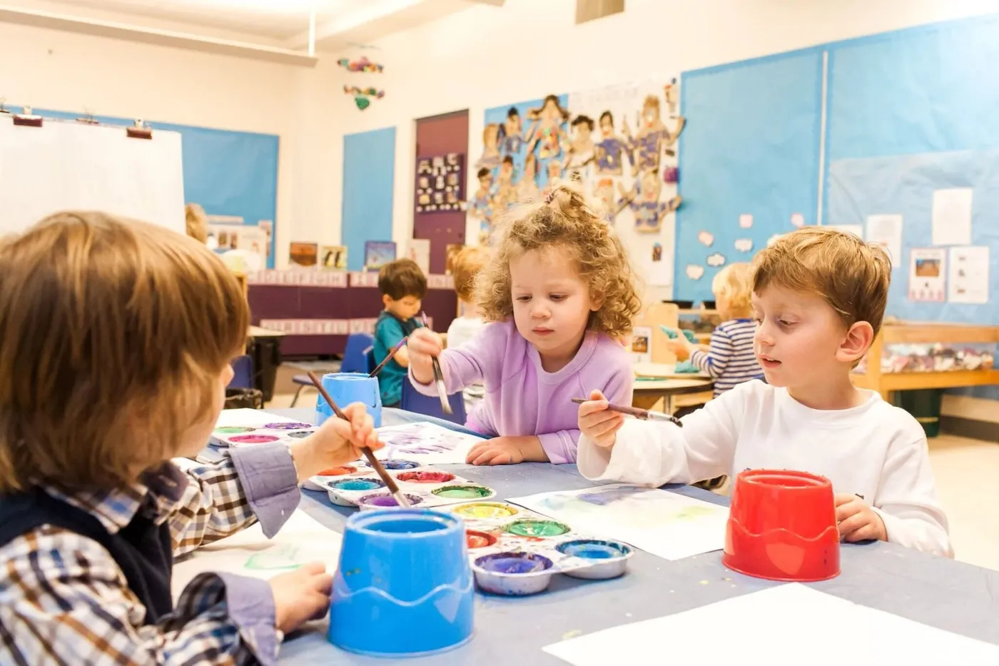 Children painting at a table in a classroom at the Frances Jacobson Early Childhood Center