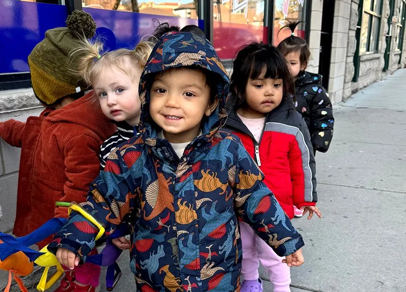 Toddlers in winter coats lined up at Wicker Park Kid’z Learning Center