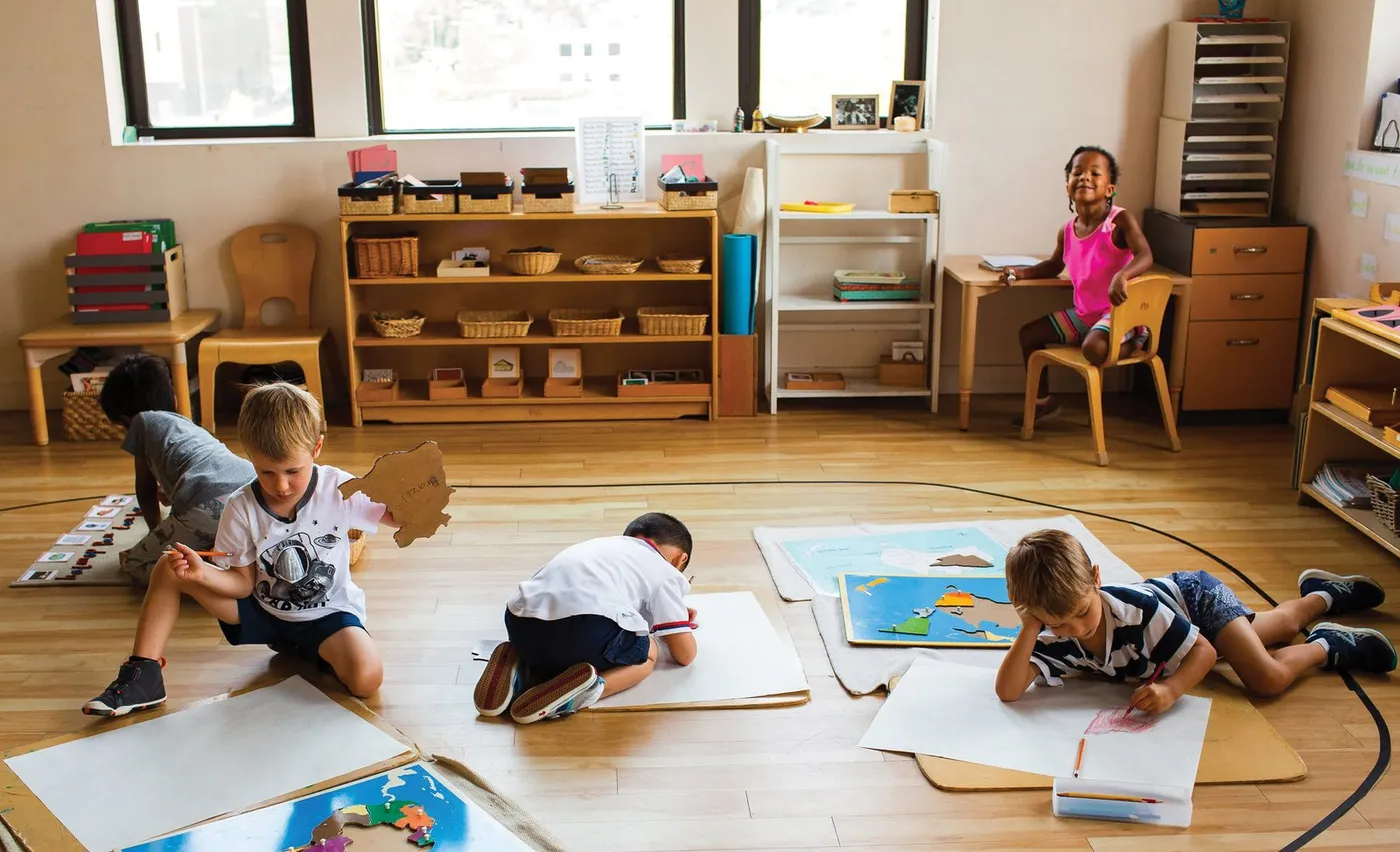 Children working on the floor of a Montessori classroom at Montessori Academy of Chicago