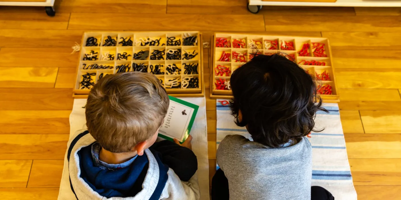 Two children working with Montessori language materials at Lifetime Montessori